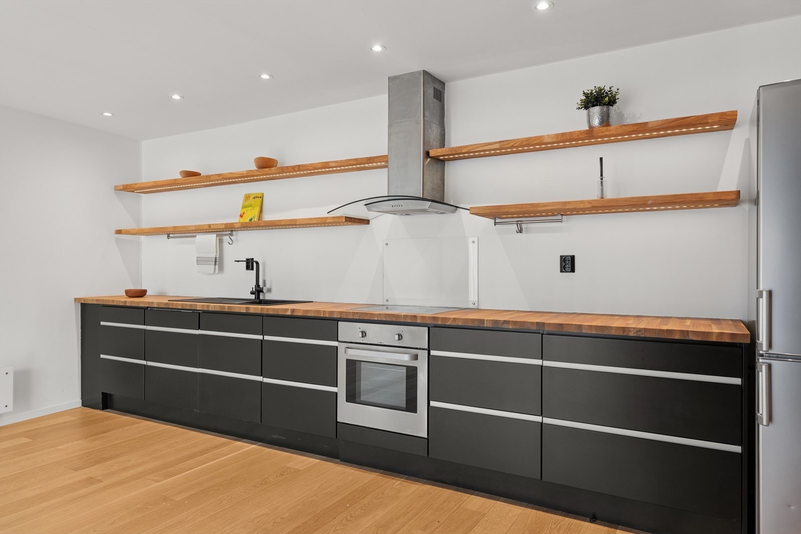 Boligen har pent kjøkken med åpen løsning til stue Galleribilde