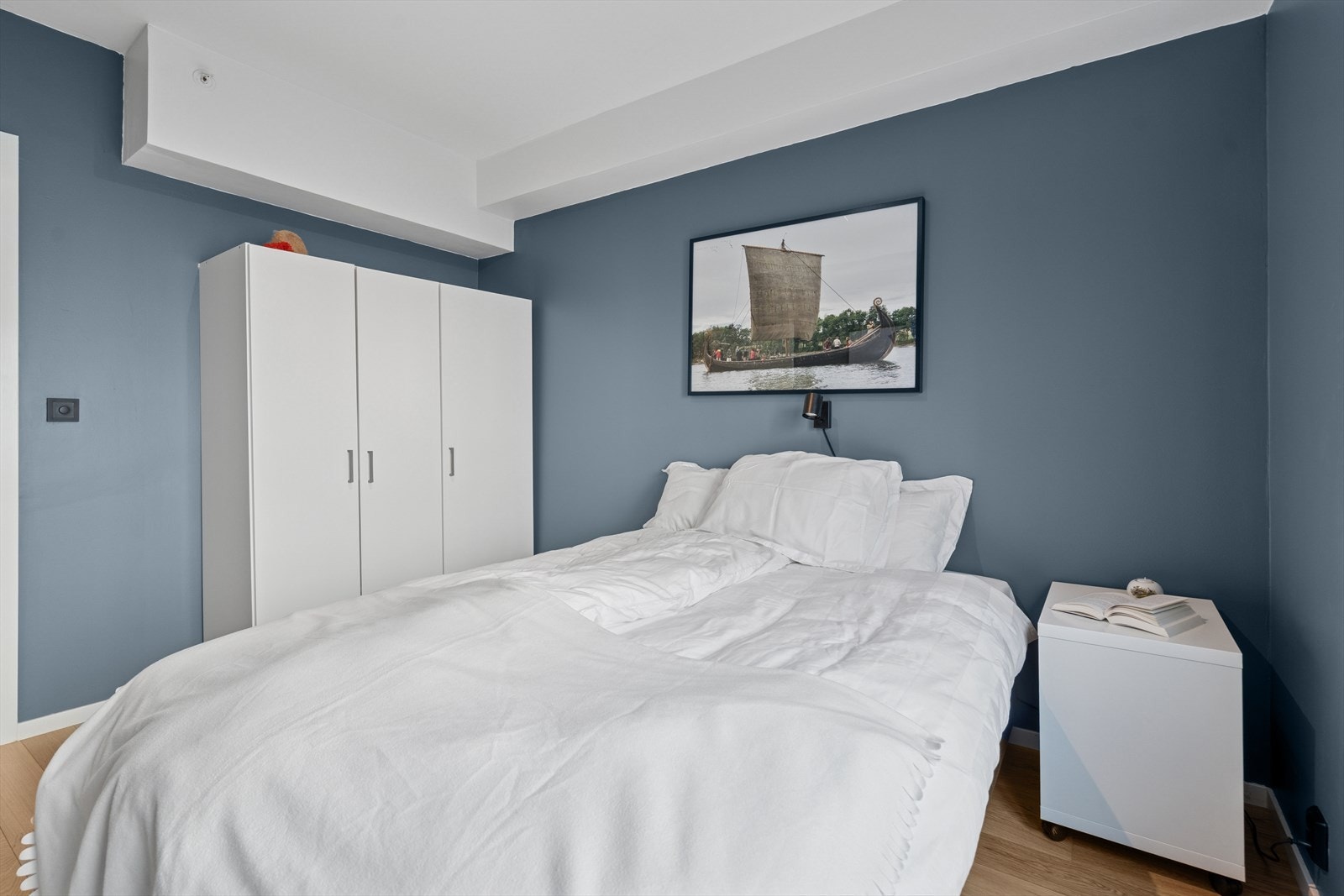 Hovedsoverommet er malt i en dus og behagelig blåfarge som gir rommet en rolig og avslappende atmosfære Galleribilde