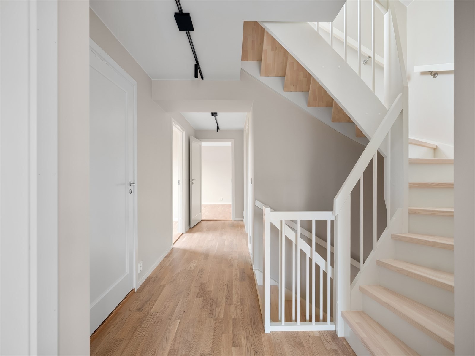 Trappen er fra Nor-Trapp med lyst laserte trinn og hvit malte vanger med trespiler. Galleribilde