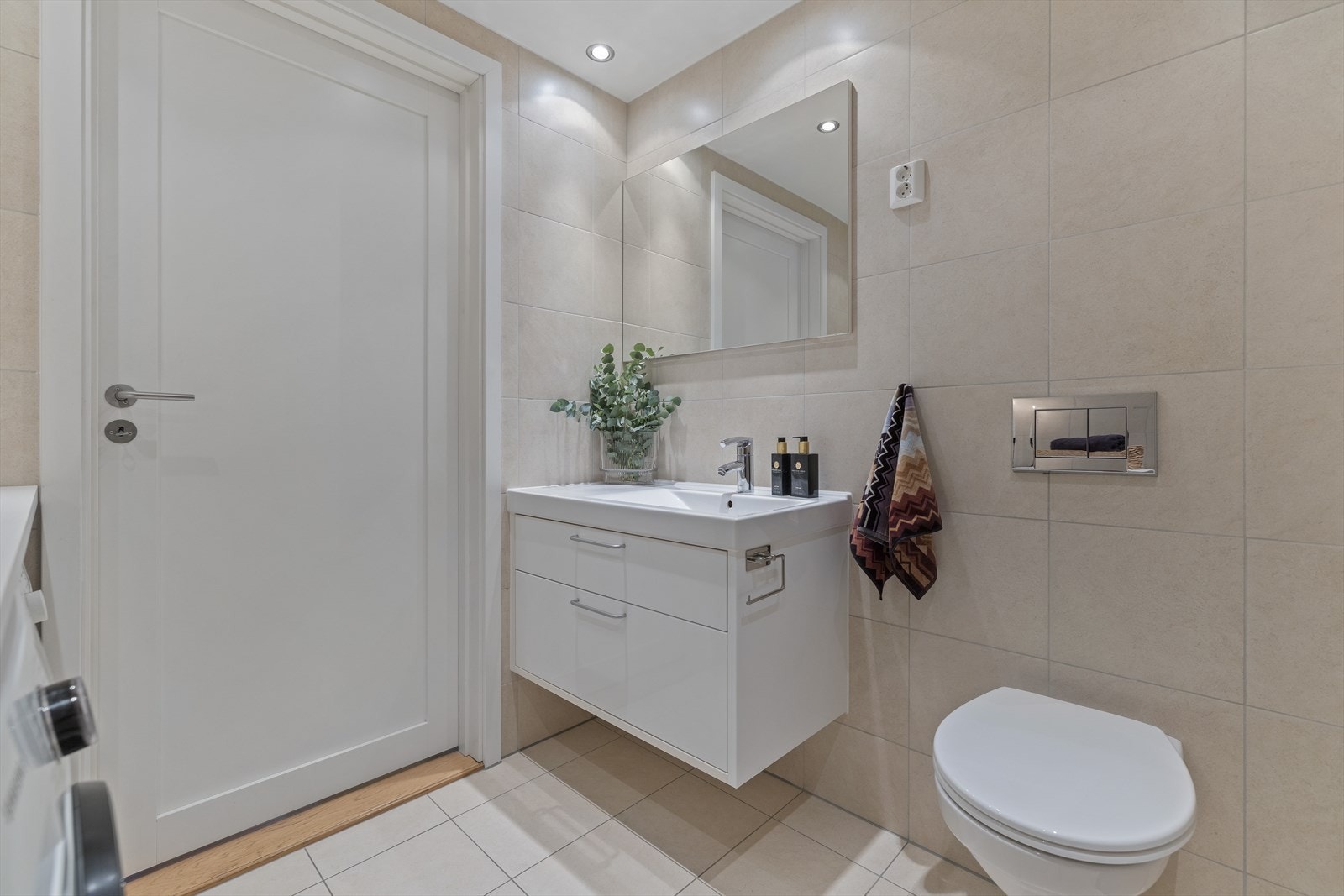 Vegghengt toalett og servant med underskap og speil over. Galleribilde