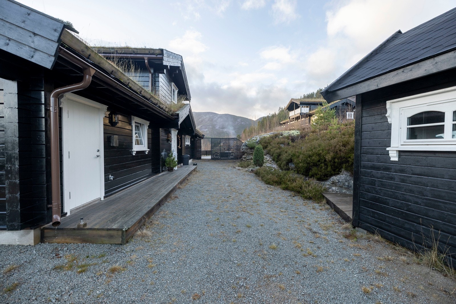 Praktisk tun med adkomst til hytte og utebod samt oppstillingsplass på tomt. Galleribilde