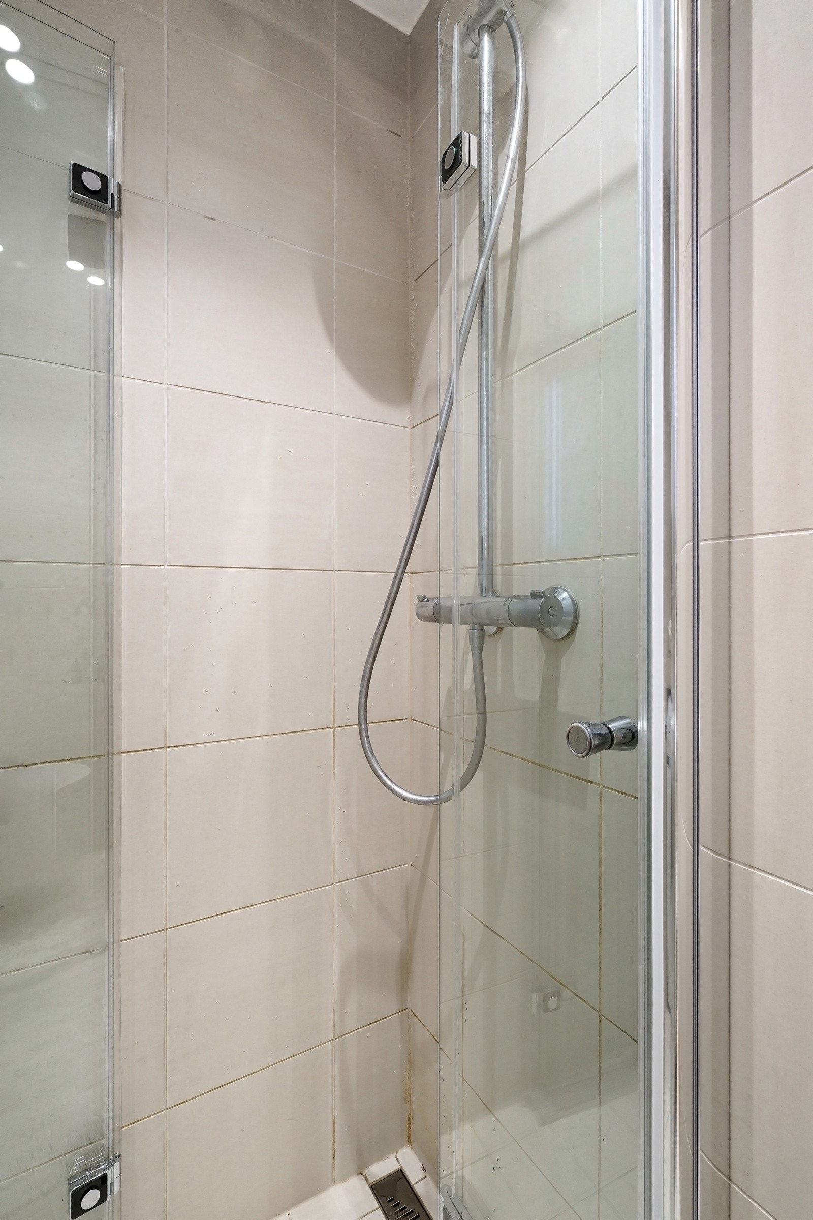 Badet har opplegg for vaskemaskin i praktisk nisje med oppbevaring over, samt dusjhjørne med innfellbare glassdører og rainfalldusj. Galleribilde