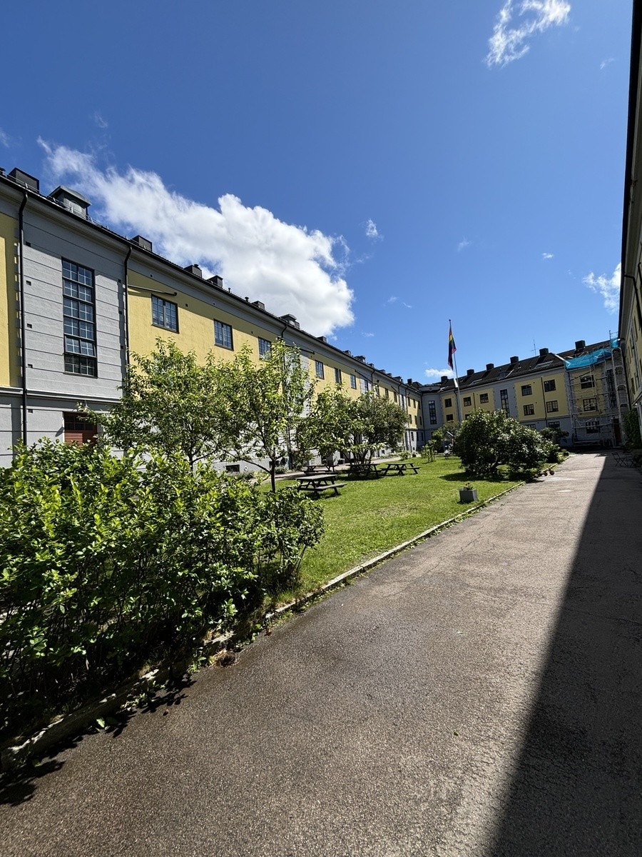 Hyggelig bakgård med flere benker og stoler. Galleribilde