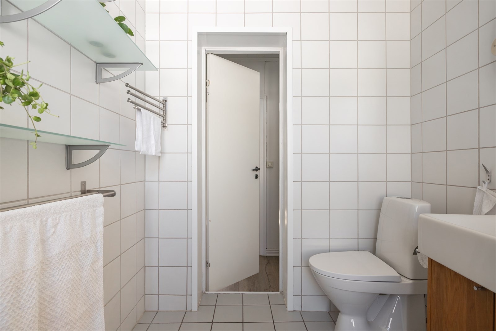 Badet har gode oppbevaringsmuligheter i fastmonterte hyller, servantskap og i høyskap Galleribilde