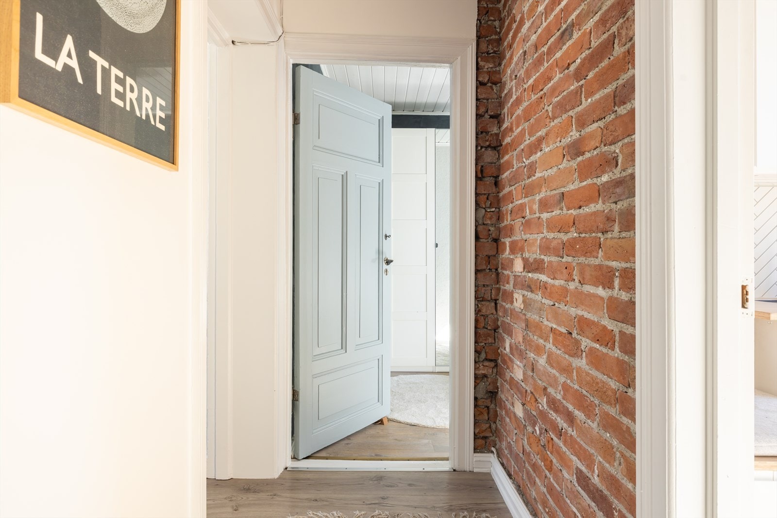 Gjennomgående flotte og sjarmerende detaljer som teglsteinsvegg og original innedør til soverommet Galleribilde