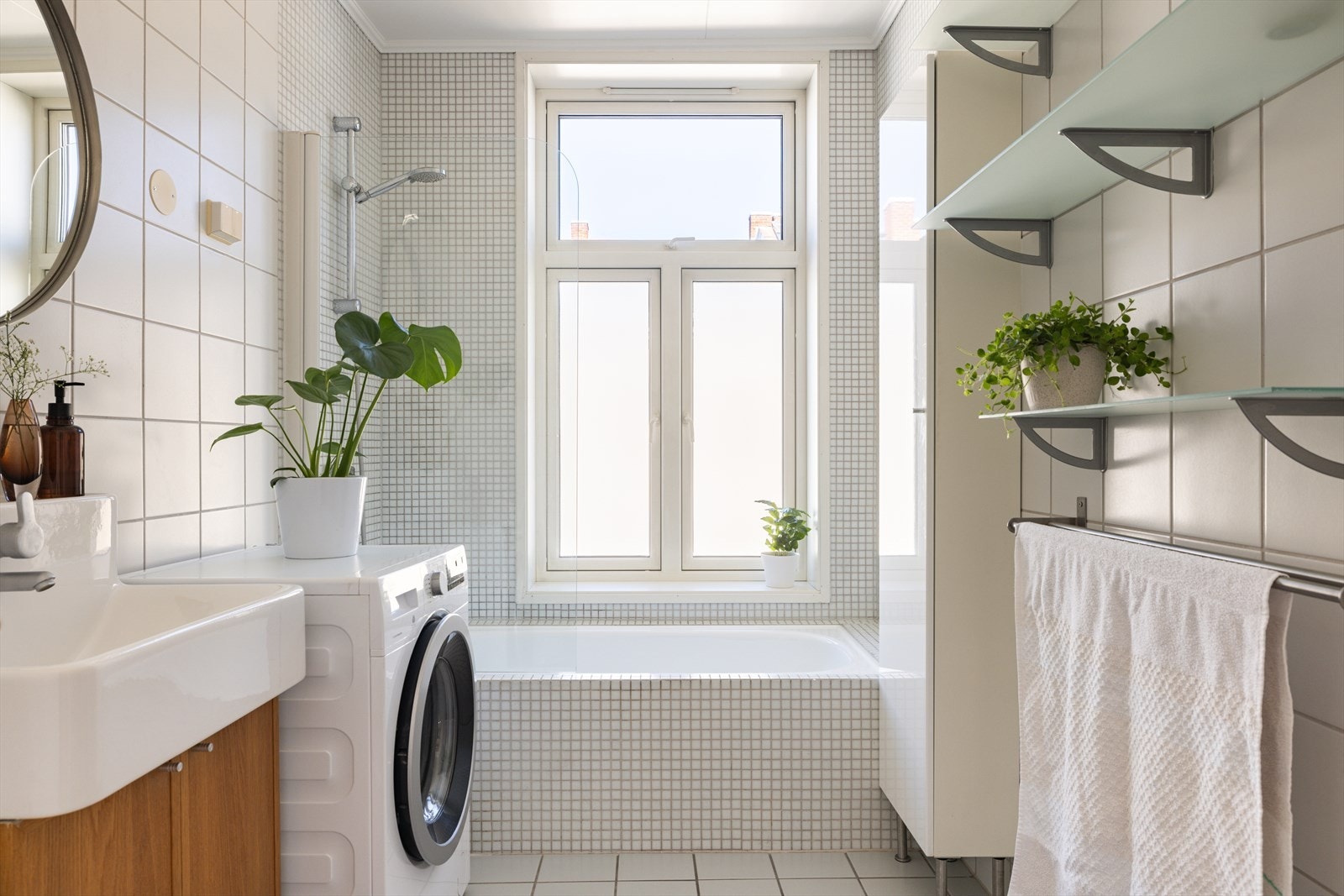 Romslig og lyst bad, med et stort vindu som slipper inn naturlig dagslys Galleribilde