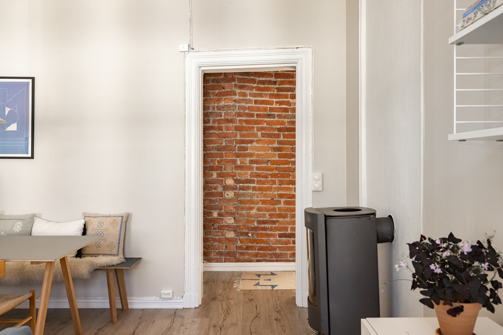 Stilig teglsteinsvegg som gir leiligheten karakter og masse sjarm Galleribilde