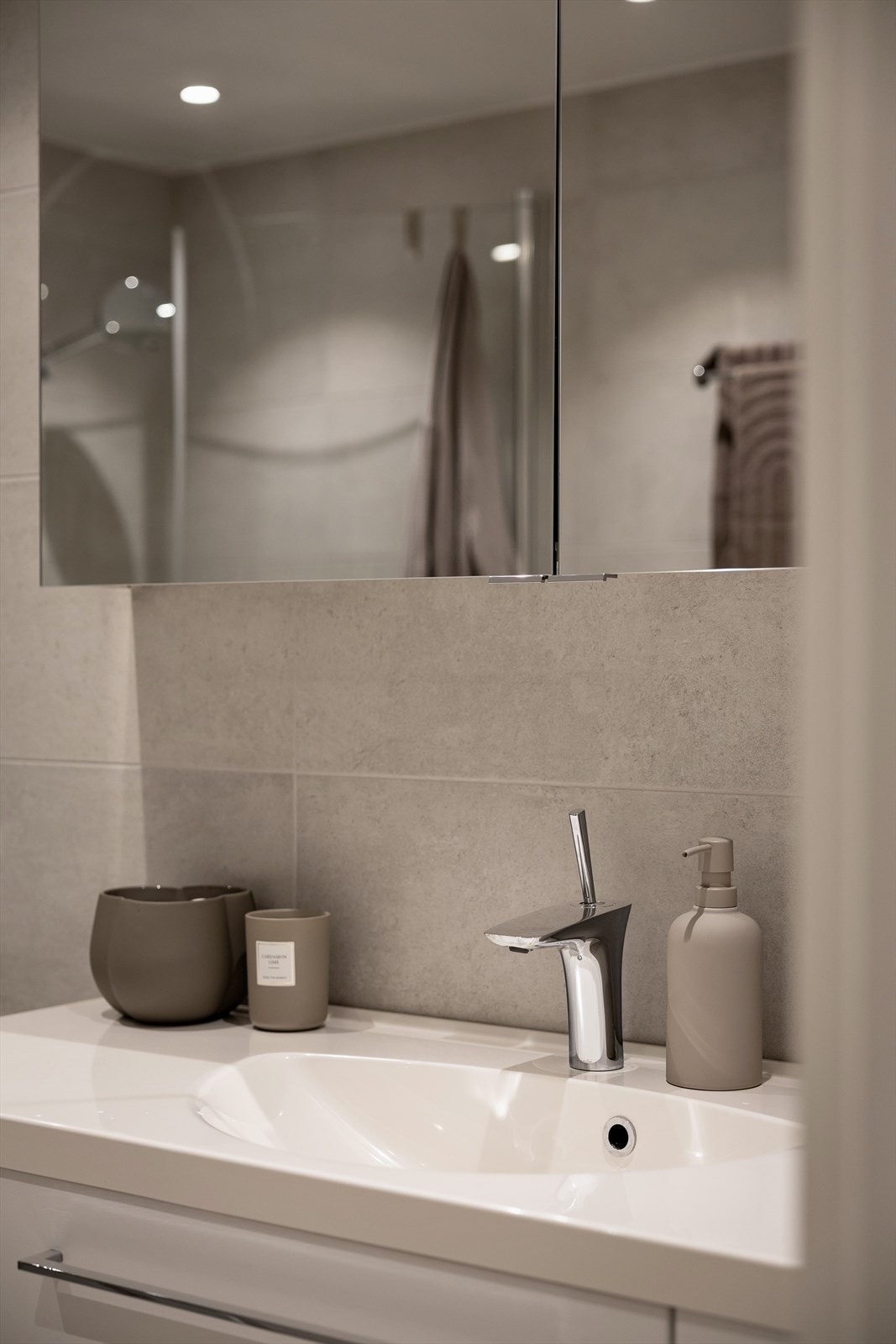 Baderomsinnredning med overskap med speil, toalett og dusjhjørne med innfellbare dusjvegger i glass Galleribilde