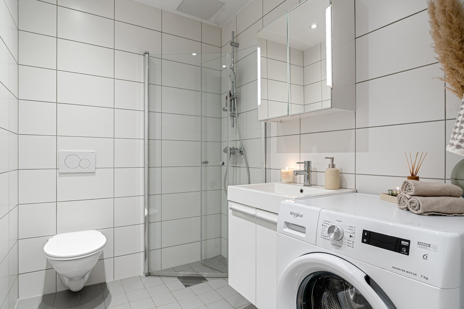 Flislagt bad med varmekabler og dusjhjørne med svingbare dusjvegger samt termostatstyrt dusjbatteri i krom med hånddusj. Galleribilde