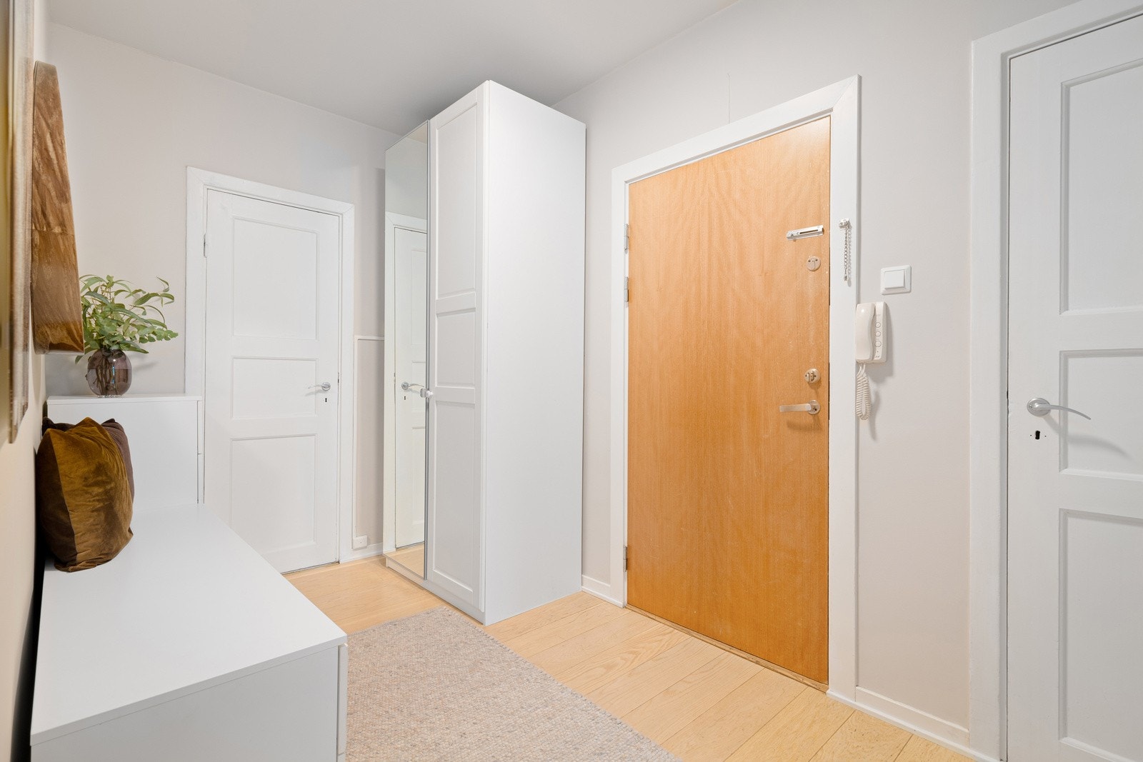 Du ønskes velkommen inn i en lys, innbydende og praktisk entré. Montert porttelefon på vegg ved inngangsdøren og sikringsskap med automatsikringer i felles trapperom. Galleribilde