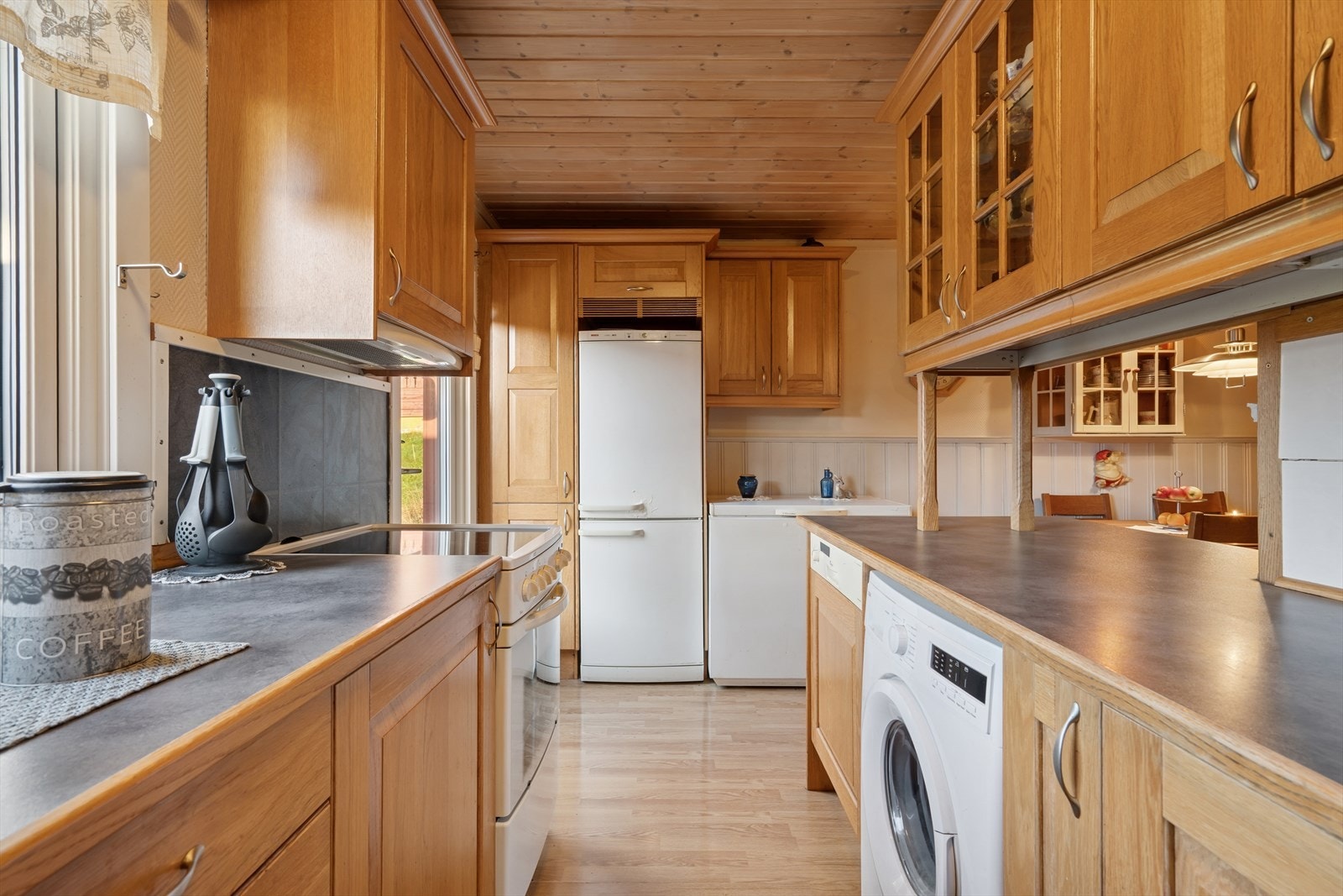 Kjøkkenet er utstyrt med frittstående hvitevarer som oppvaskmaskin, komfyr, fryseboks og kjøl/frys, i tillegg til vaskemaskin. Galleribilde