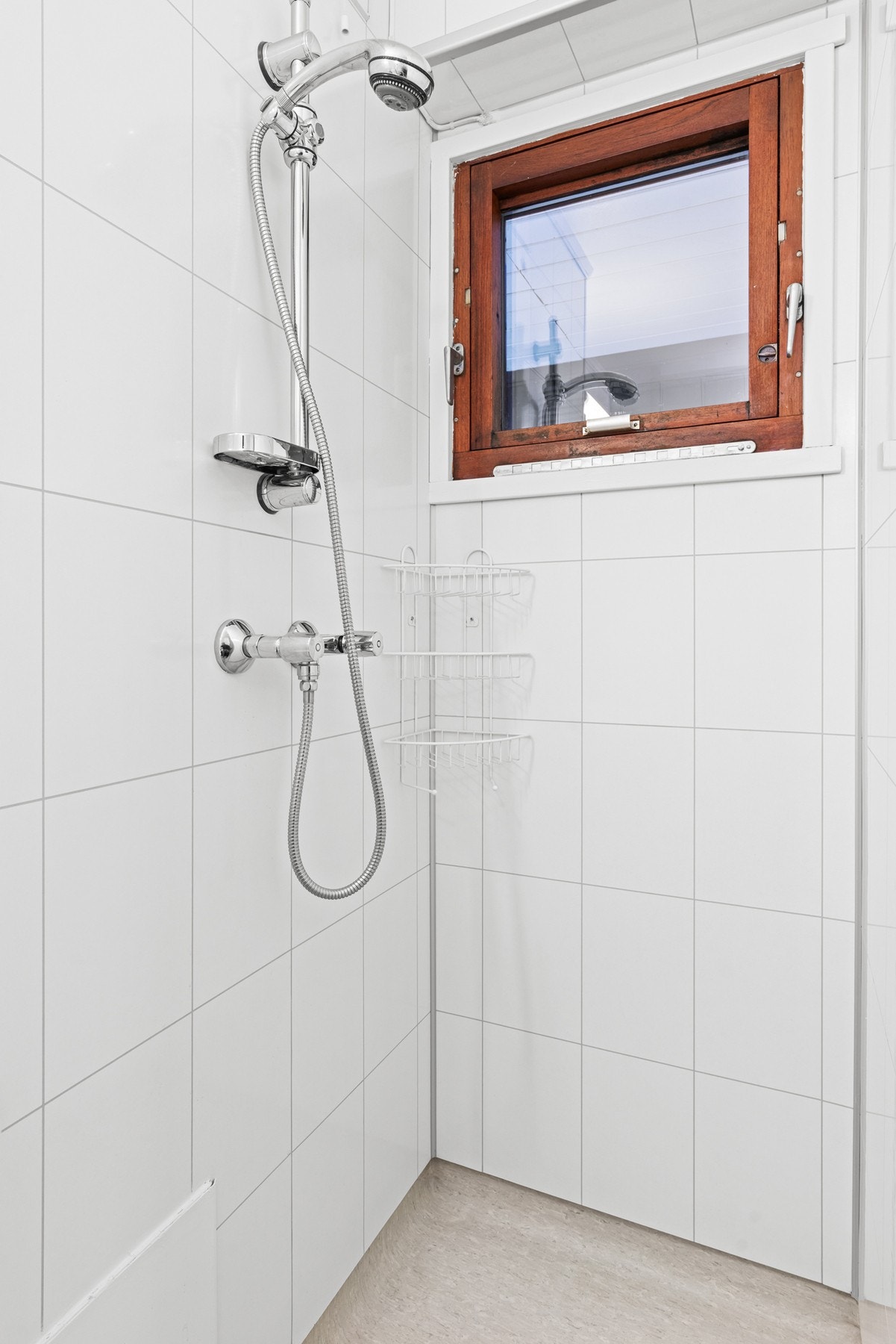 Badet har en L-utforming med dusjhjørne i enden Galleribilde