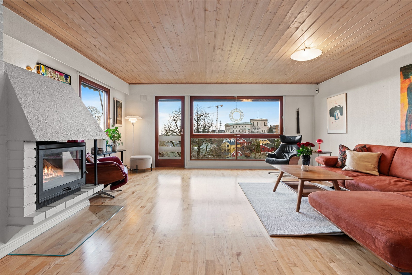 Det er peis til vedfyring, varmepumpe og parafinovn i rommet Galleribilde