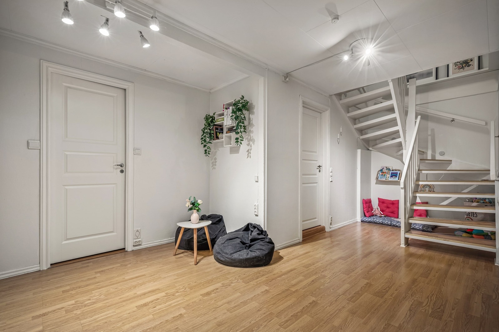 En romslig trappegang med praktisk skyvedørsgarderobe gir både plass og orden. Rommet har en åpen og luftig utforming, og selger har valgt å innrede det som en ekstra stue for barna. Galleribilde