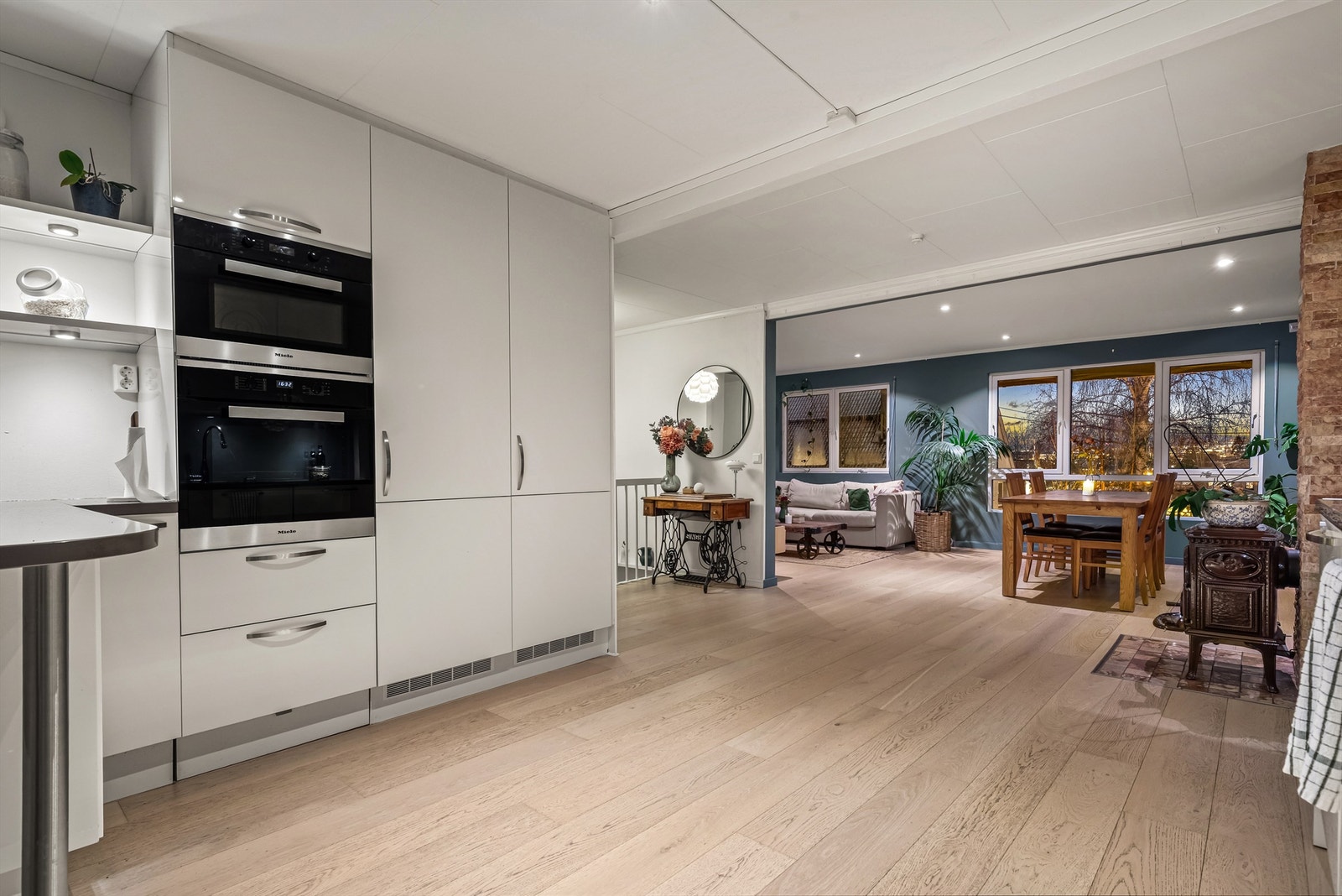 I 1. etasje finner du en lys og romslig stue, spisestue og kjøkken i åpen løsning. Et herlig rom med store vindusflater. Foto: Oh Shots Galleribilde