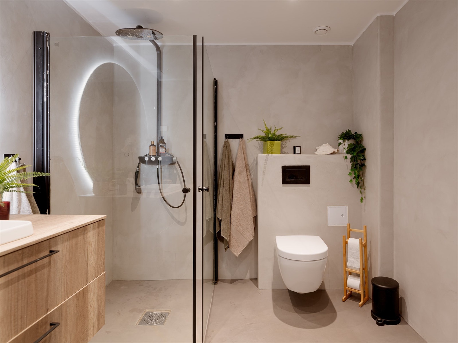 Innredningen består av porselensservant nedfelt i laminat benkeplate med underliggende skap, veggmontert speil med integrert lyslist, veggklosett og dusjnisje med svingbare glassvegger i herdet glass. Opplegg til vaskemaskin. Galleribilde