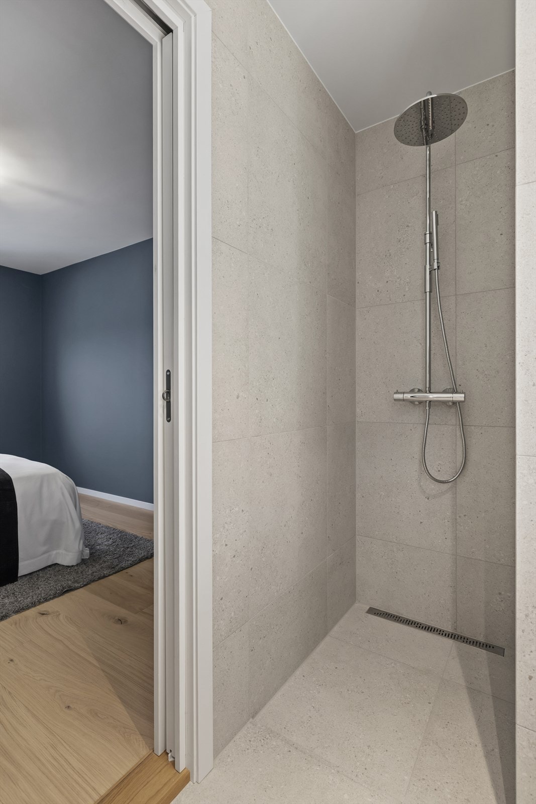 Rommet har innredning med to nedfelte servanter, veggmontert toalett og dusjvegger/hjørne. Galleribilde