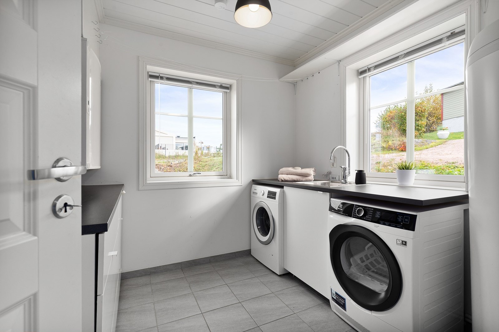 Praktisk vaskerom i første etasje med flislagt gulv, god arbeidsplass, nedfelt vaskekum og opplegg for vaskemaskin. Galleribilde
