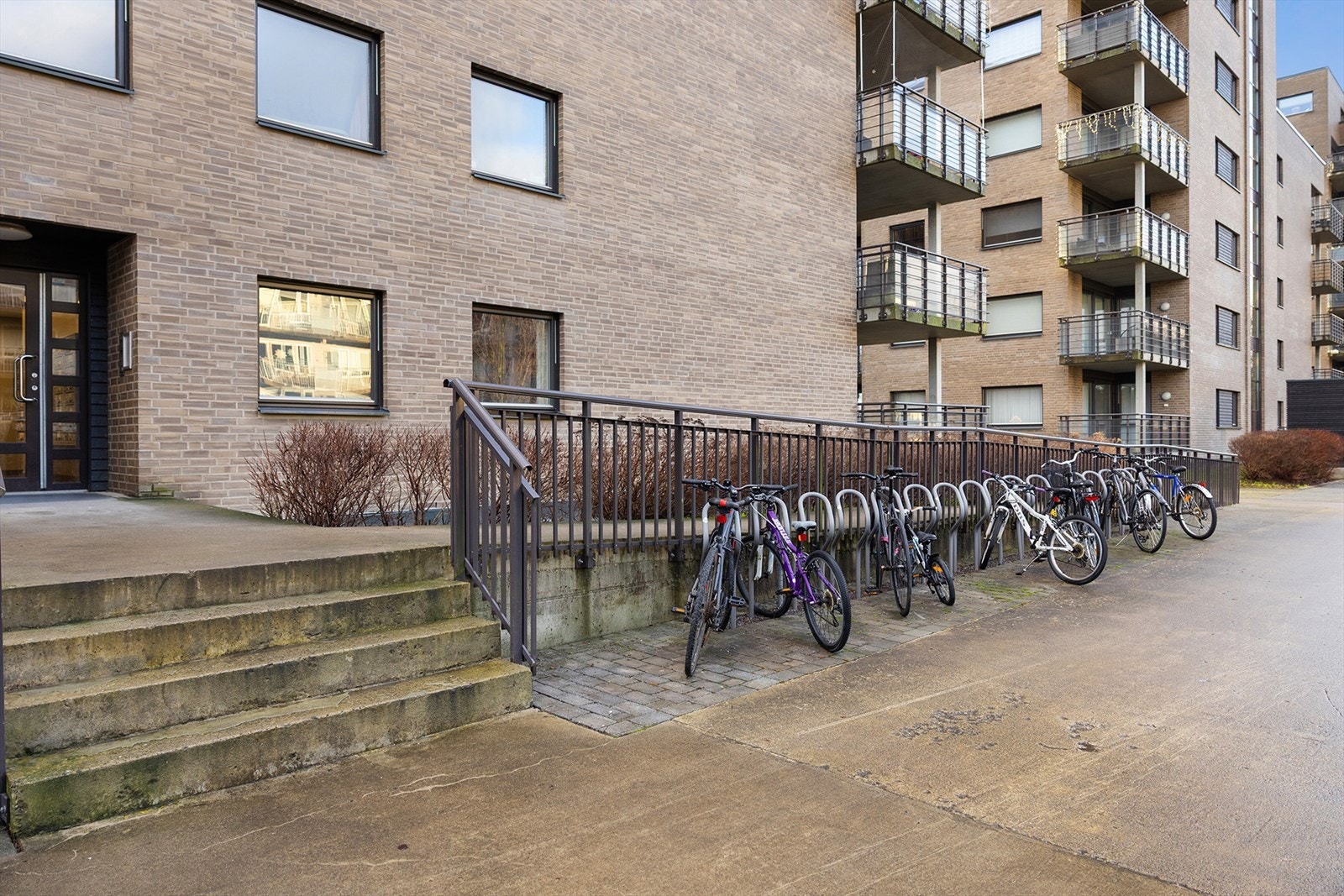 Utvendig sykkelparkering og to store felles sykkelboder innendørs. Galleribilde