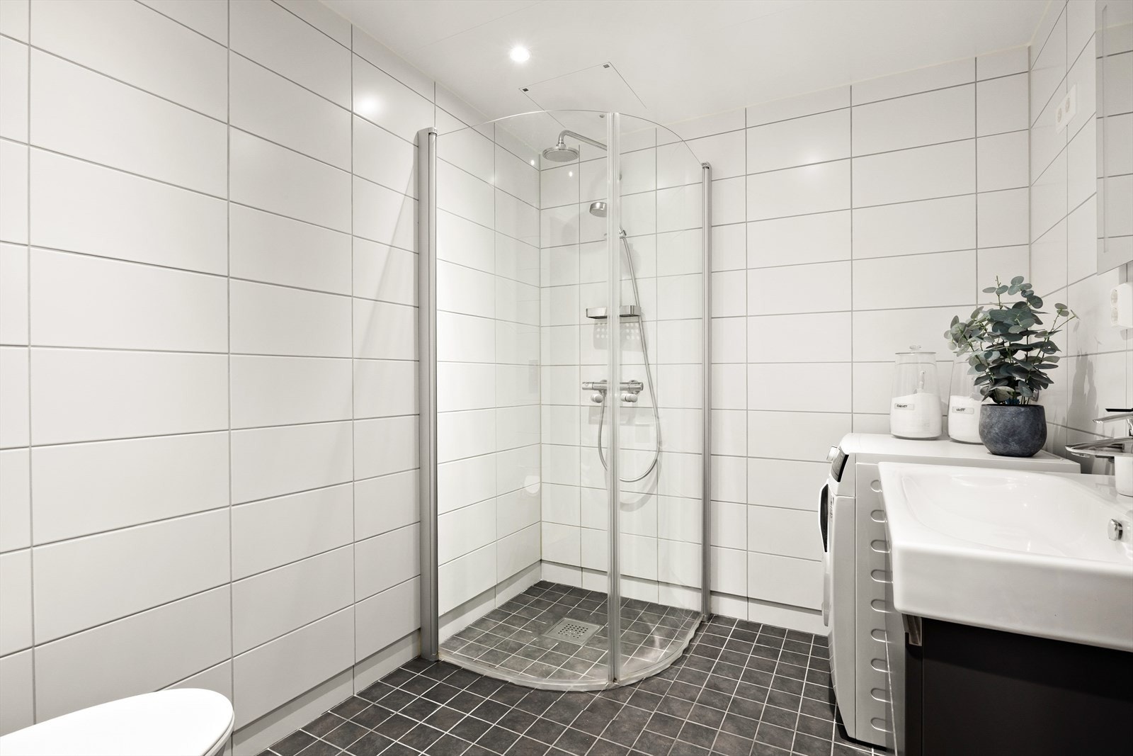 Dusj med innfellbare dører i herdet glass og opplegg for vaskemaskin. Galleribilde