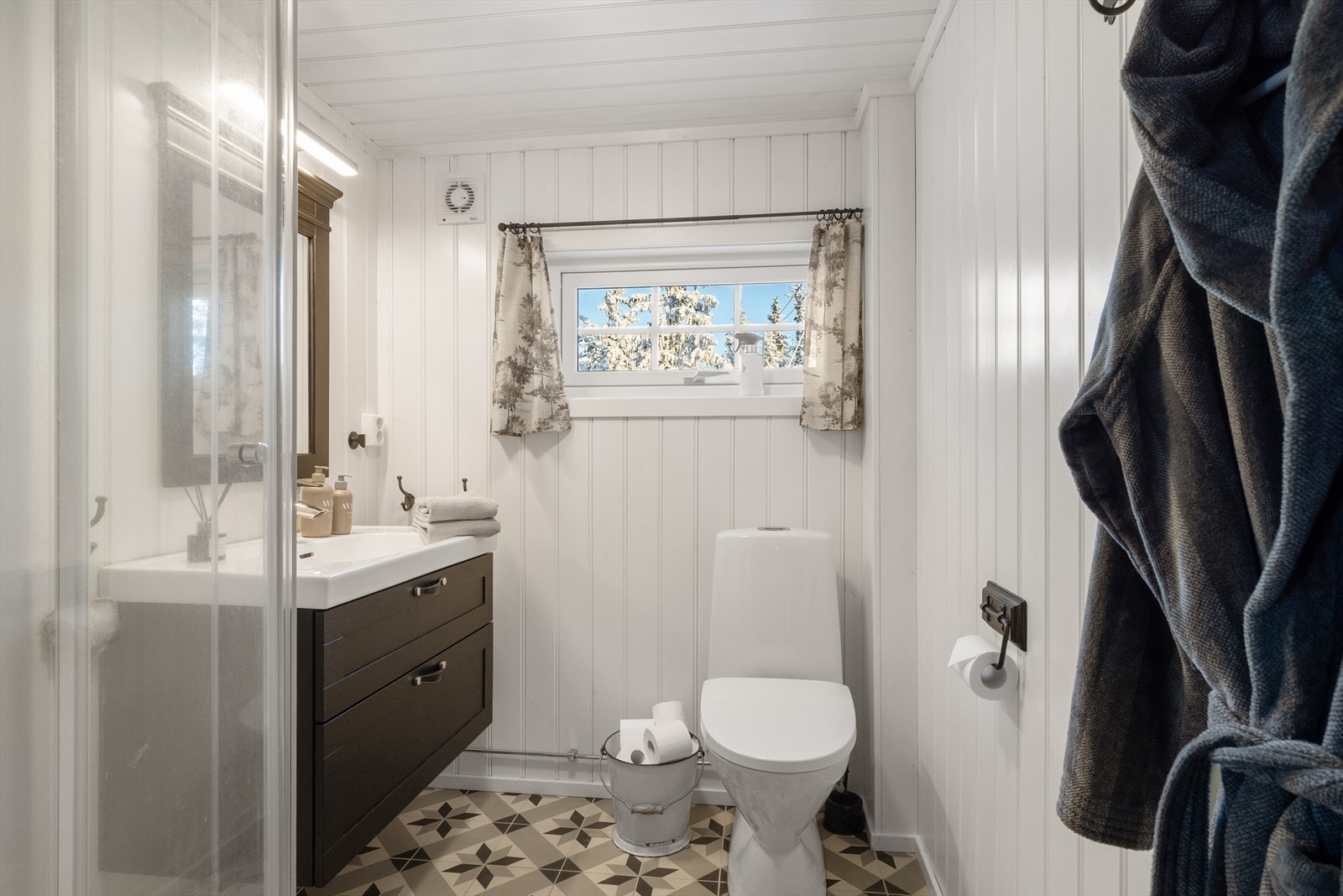 Badet har flis på gulv med varmekabler. Rommet er innredet med servantskap med skuffer og overligge servant, gulvmontert toalett og
dusjkabinett. Galleribilde