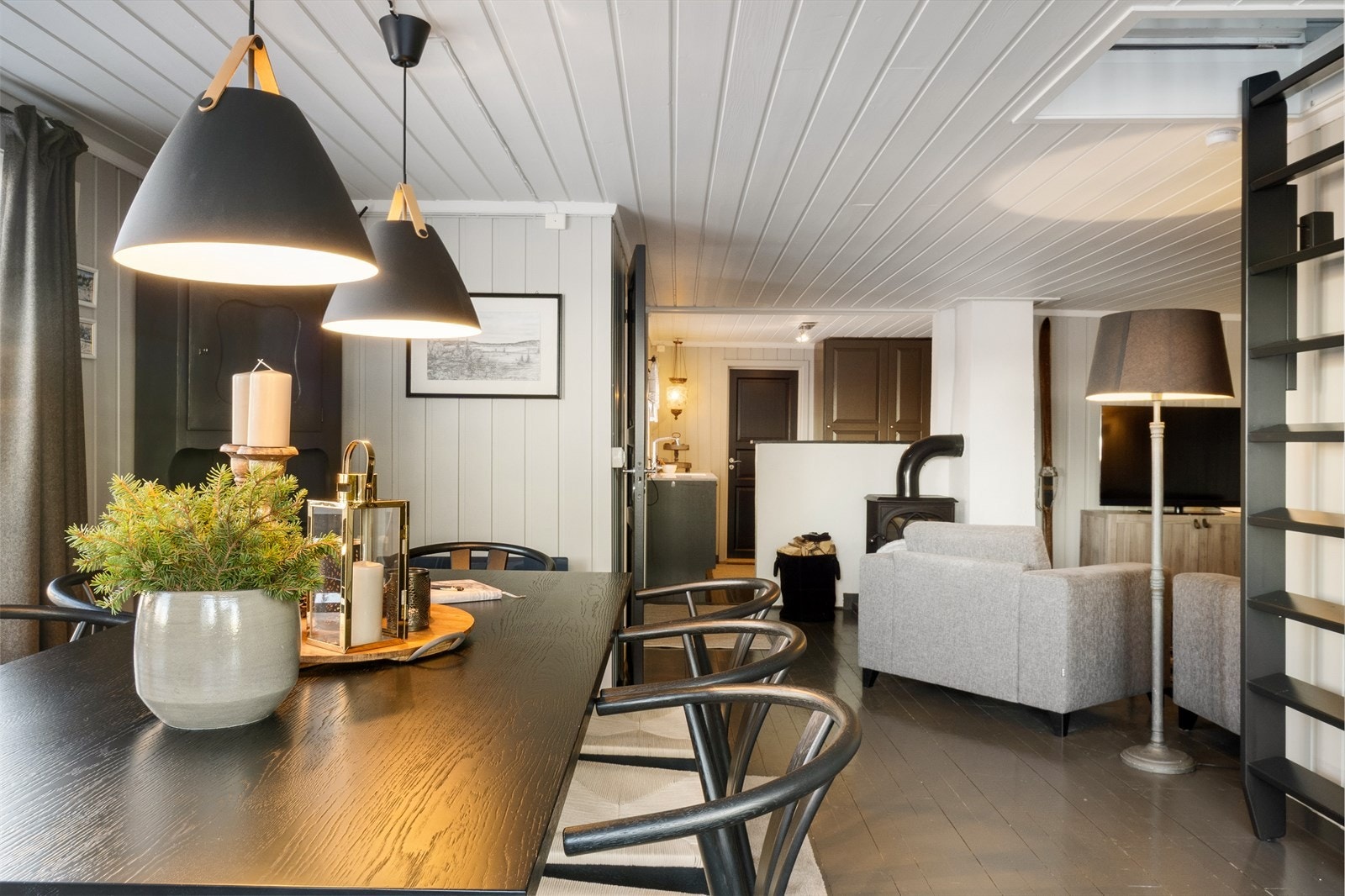 Lun hytte med malte tregulv og lysmalt panel på vegger og i tak. Galleribilde