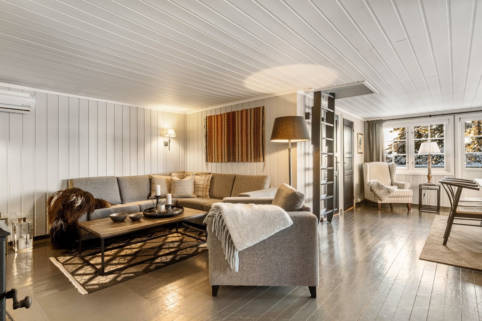 Stuen har en fin utforming med et lunt uttrykk med lyse overflater Galleribilde