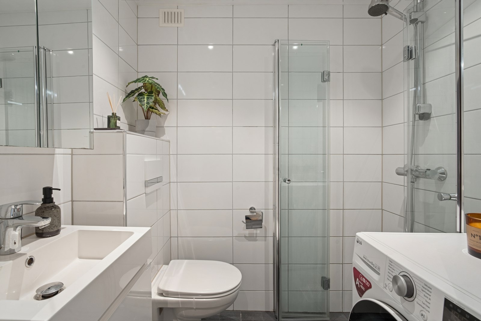 Baderommet er renovert i 2017 med flislagte overflater på både gulv og vegger. Det er varmekabler i det støpte gulvet og downlights i den malte himlingen. Galleribilde