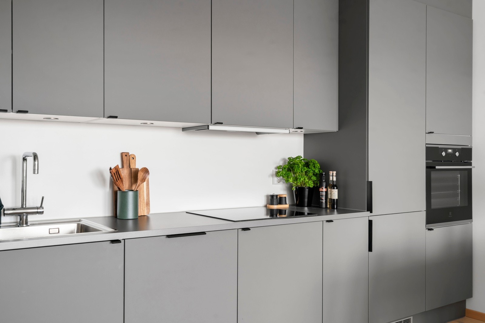 Innredningen består av glatte, folierte fronter og laminat benkeplate med nedfelt kum i rustfritt stål. Galleribilde