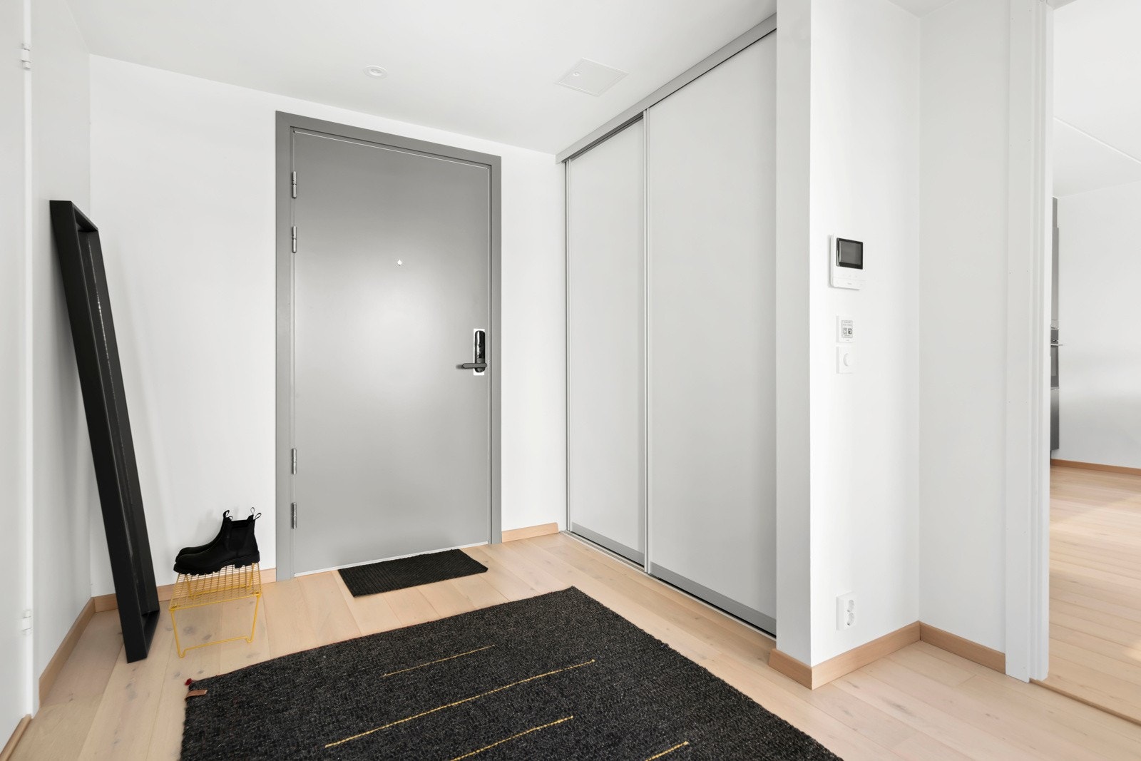 Leiligheten har en ryddig og innbydende entré/gang med plass til oppbevaring av klær i garderobeskap. Galleribilde