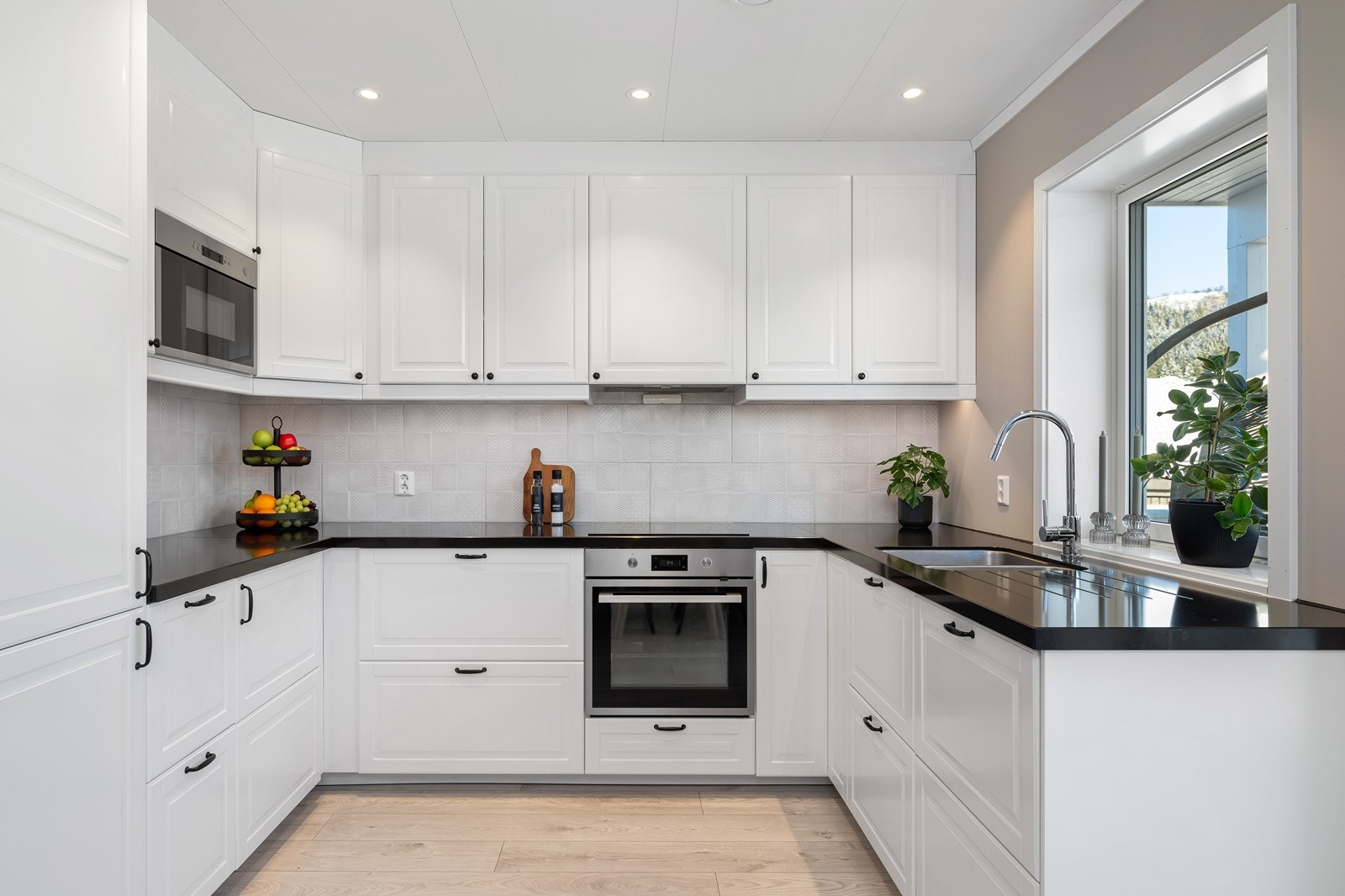 Effektivt kjøkken med flott profilert innredning, benkeplate i stein og rikelig med oppbevaringsplass. Galleribilde