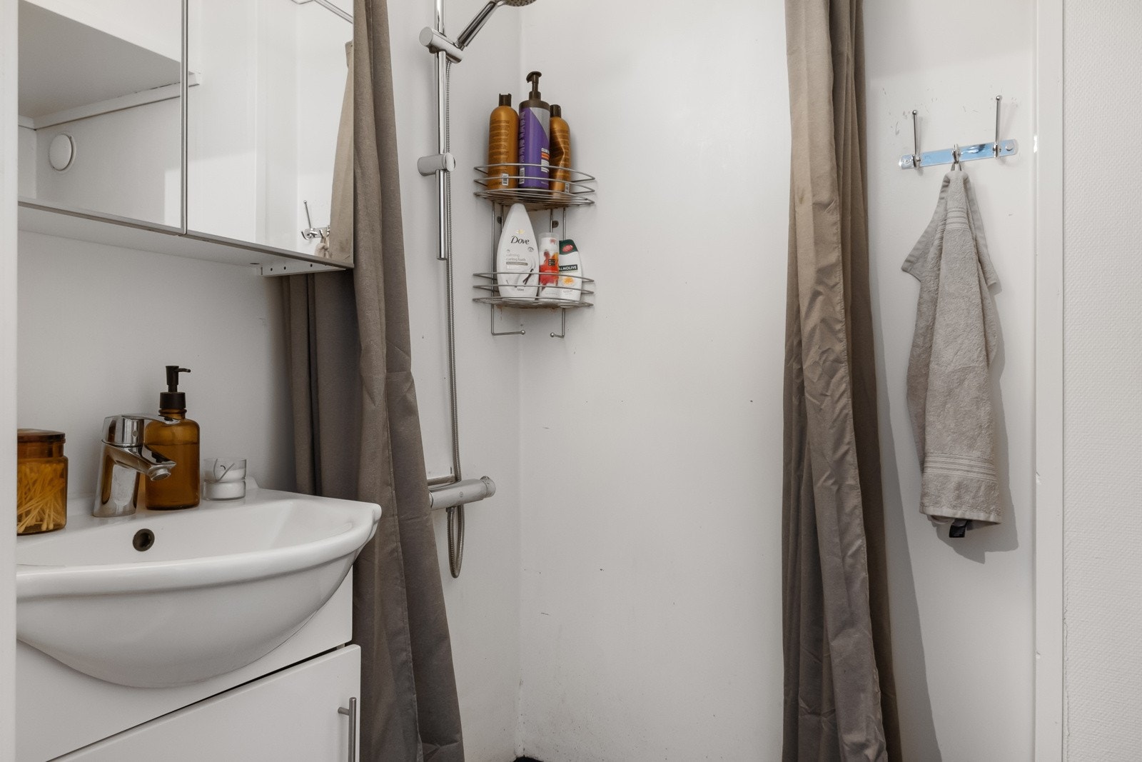 Badet har servant med underskap, gulvmontert toalett & dusj med forheng. Galleribilde