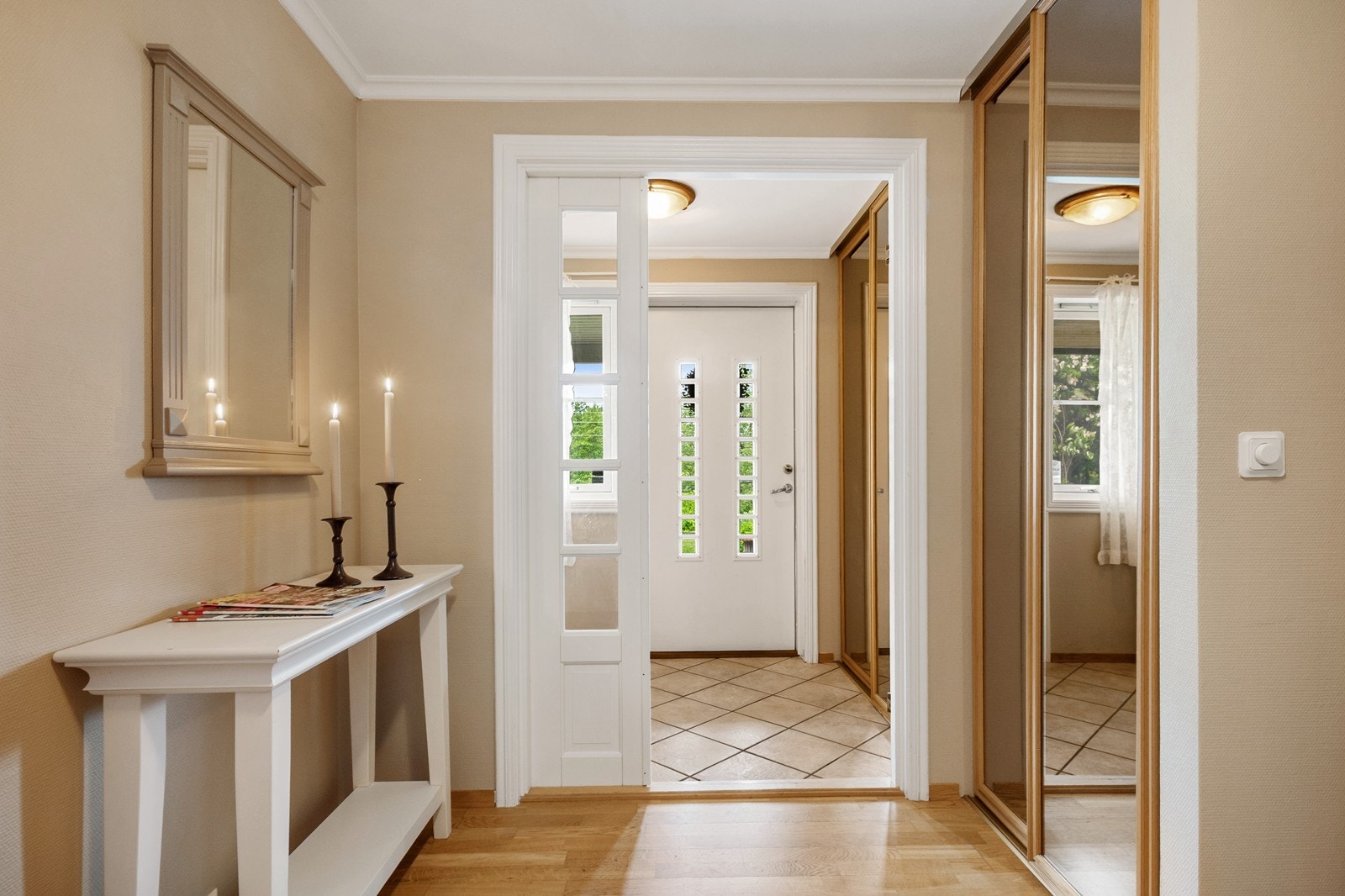 "Hoveddelens" vindfang og hall har to skyvedørsgarderober med speilfronter og fliser eller gyllen eikeparkett på gulv. Galleribilde