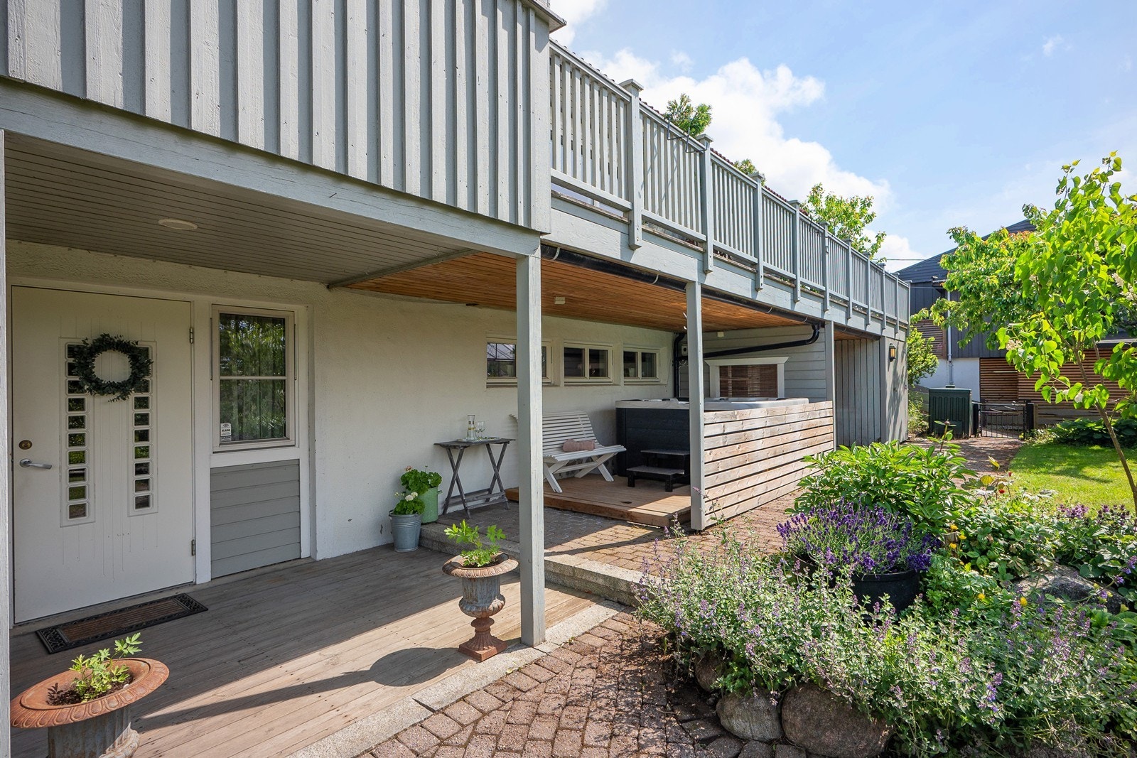Her er det frodige bed og flere nivåer med terrasseplatting og steinbelagte partier. Galleribilde