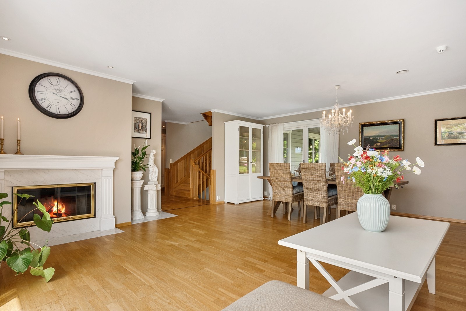 Dagslyset suppleres fint av downlights og taklampe, og lune kvelder sikres av en elegant peis med dekorativ hvit ramme rundt. Galleribilde