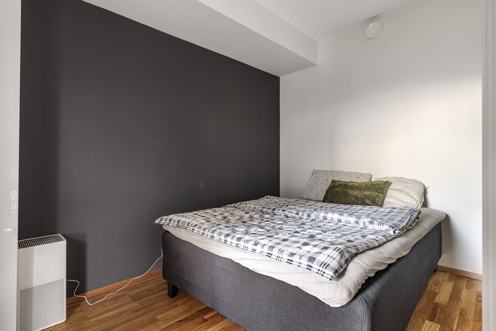 Soverommet har en lun atmosfære med mørk kontrastvegg, plass til dobbeltseng, nattbord og et stort garderobeskap. Galleribilde