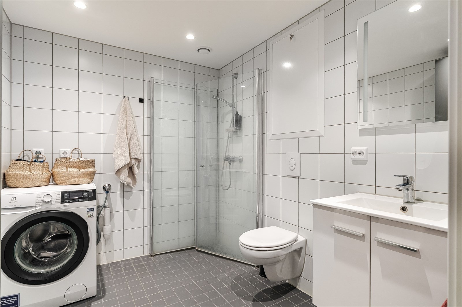 Moderne baderom med lyse fliser og god belysning. Gulvvarme og balansert ventilasjon. Galleribilde