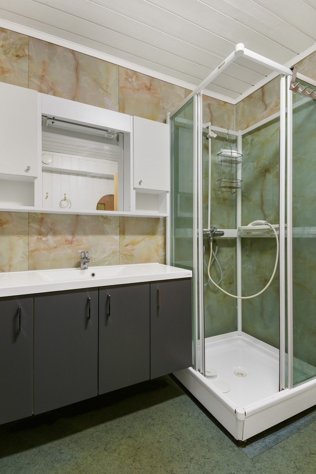 Dusjrommet har trepanel kombinert med baderomsplater i våtsonen, gulv med belegg, servantskap, speil og dusjkabinett. Rommet har TG2 som følge av alder. Galleribilde