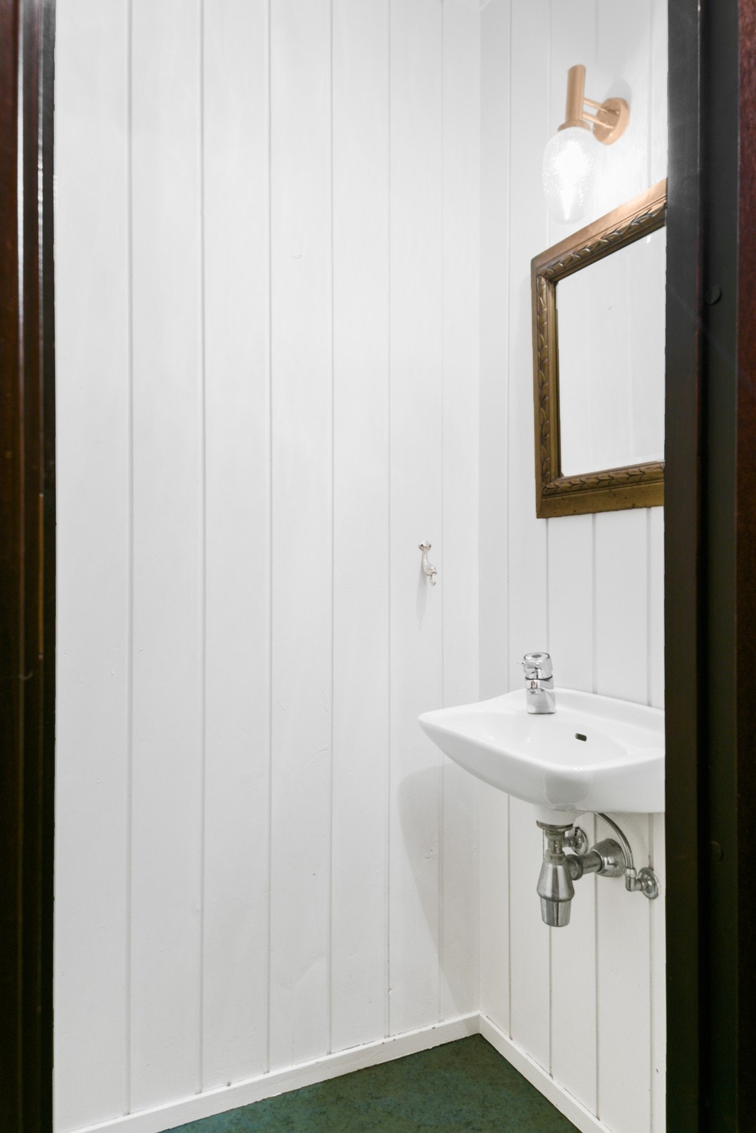 Like ved ligger et separat toalettrom med gulvfestet toalett og veggmontert servant. Innfesting for servant bør utbedres. Galleribilde