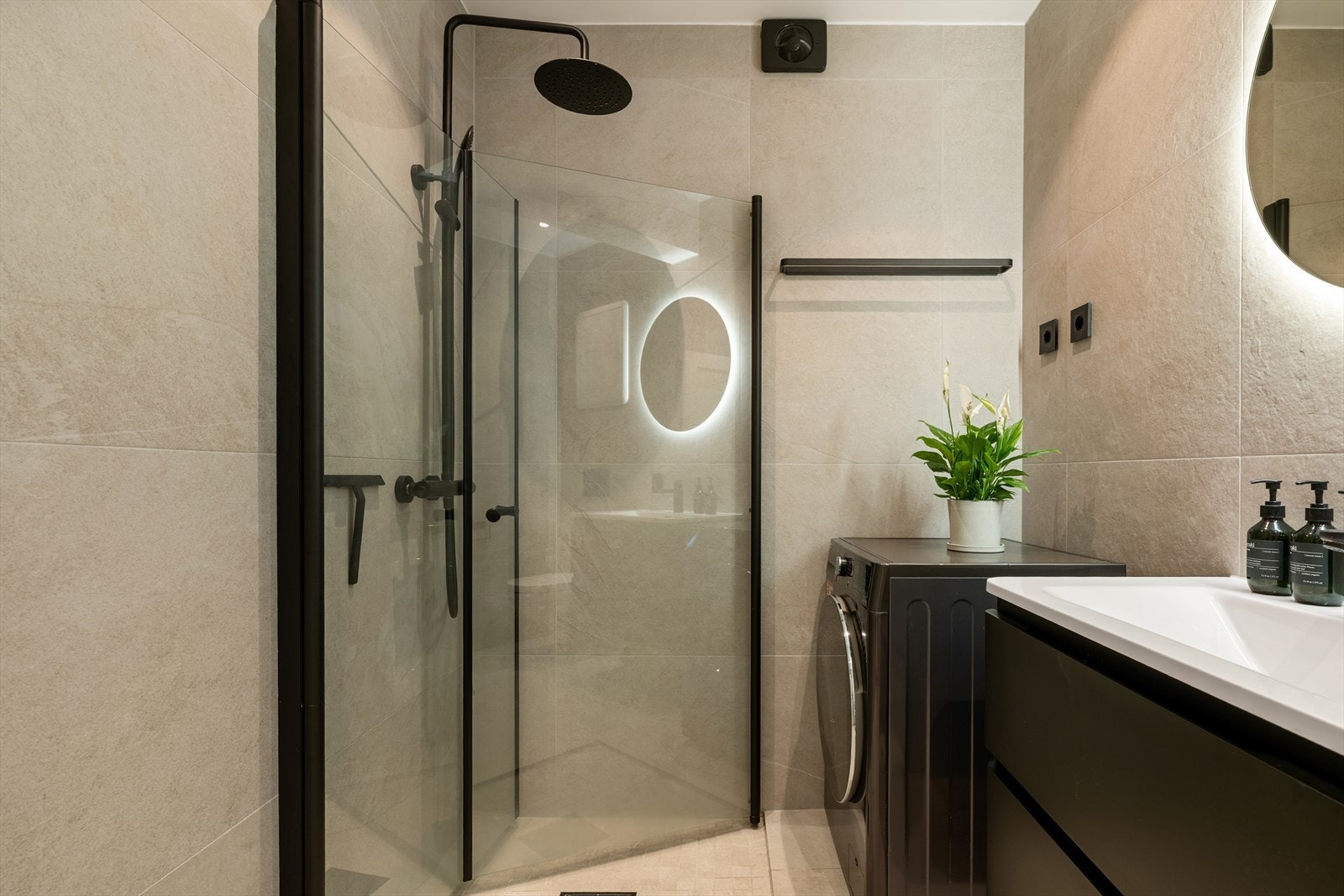 Innredning bestående av innfellbare dusjdører, naturlig avtrekk, opplegg for vaskemaskin, servantskap, veggmontert wc, rørfordelingsskap og stoppekran. Galleribilde