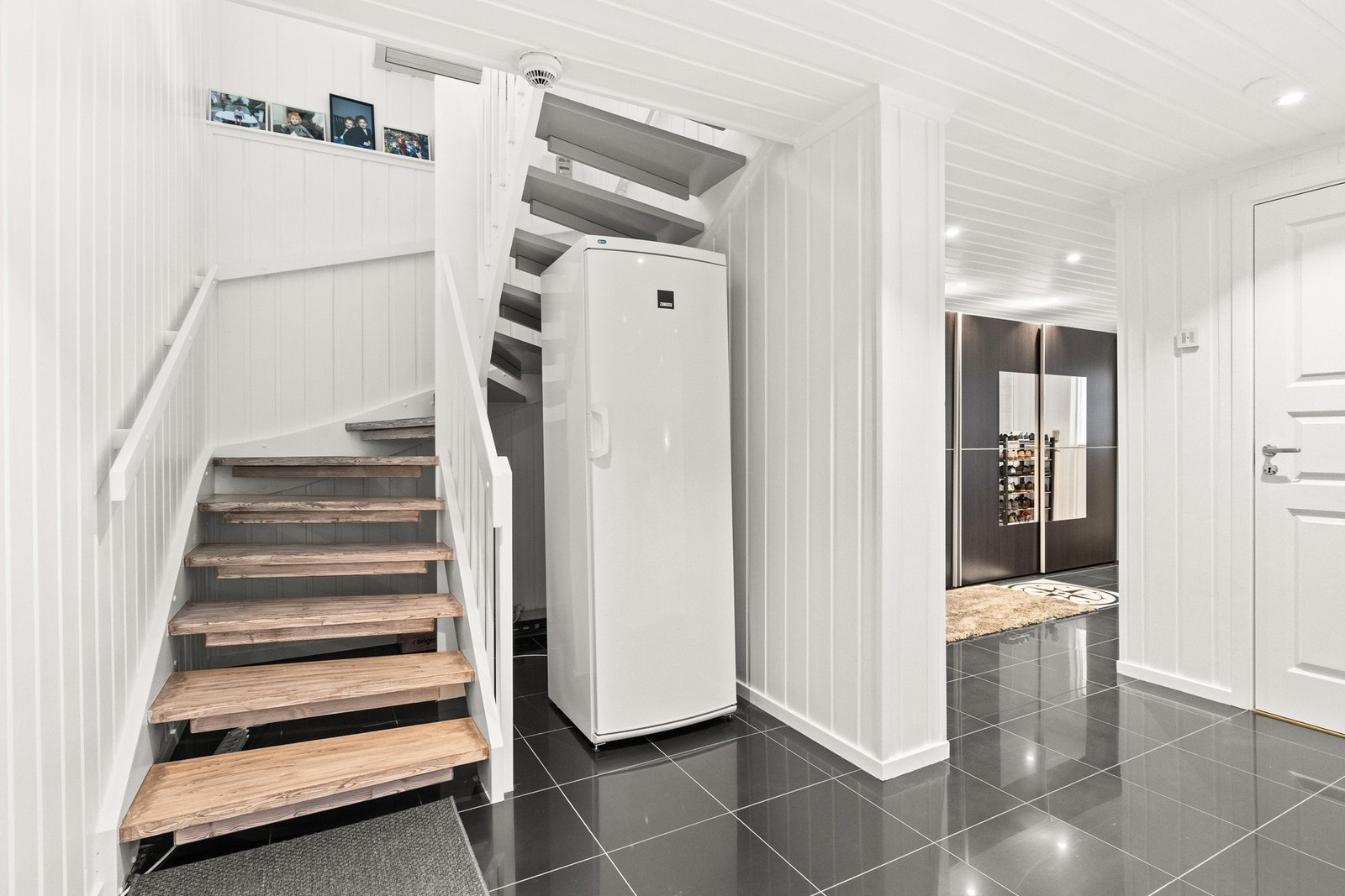 Flislagte gulvflater, gir en praktisk løsning for rengjøring når våte sko og yttertøy tas av Galleribilde