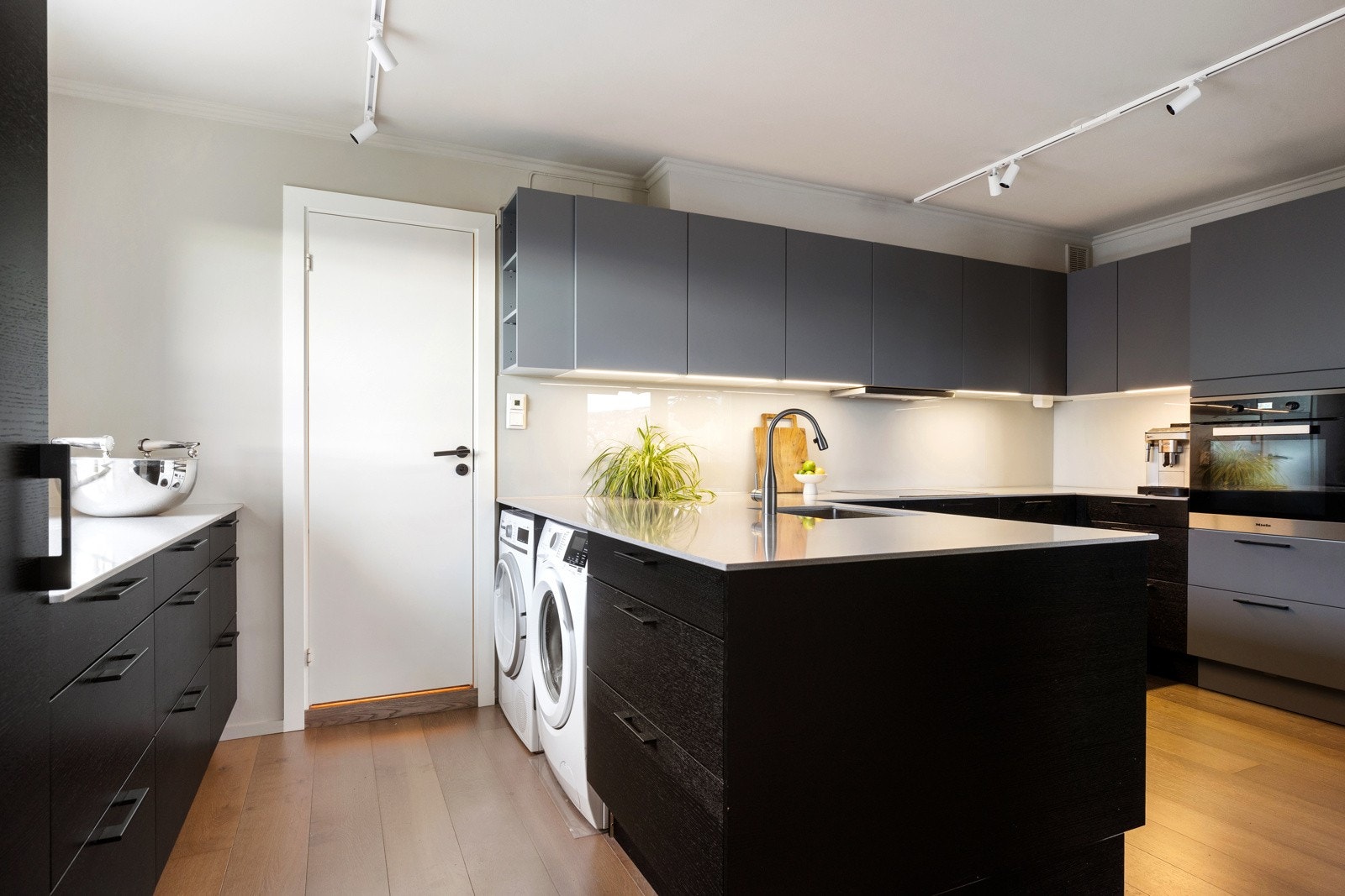 På baksiden av kjøkkeninnredningen er det opplegg for vaskemaskin og tørketrommel Galleribilde