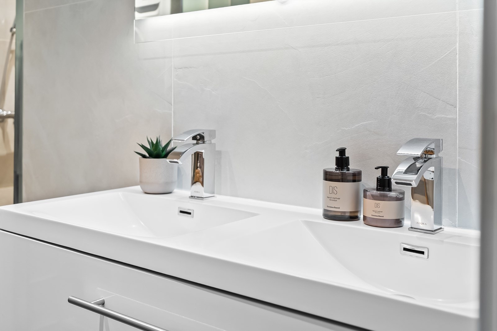 Dobbel servant på skuffeinnredning med speil og belysning over. Galleribilde