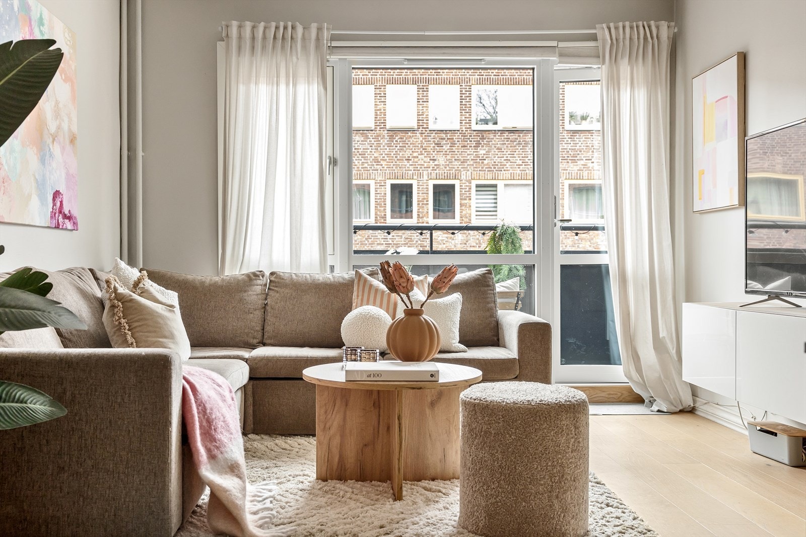 Dagslyset fra de store vinduene forsterker romfølelsen og gjør stuen til et naturlig oppholdsrom. Galleribilde