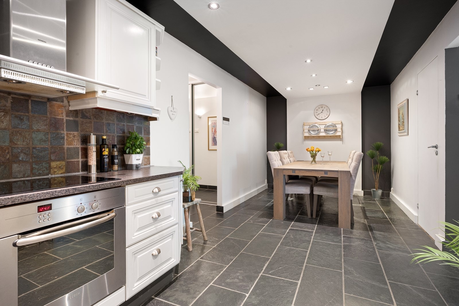 Flislagt gulv, malte overflater og downlights i tak skaper et stilfullt rom. Galleribilde