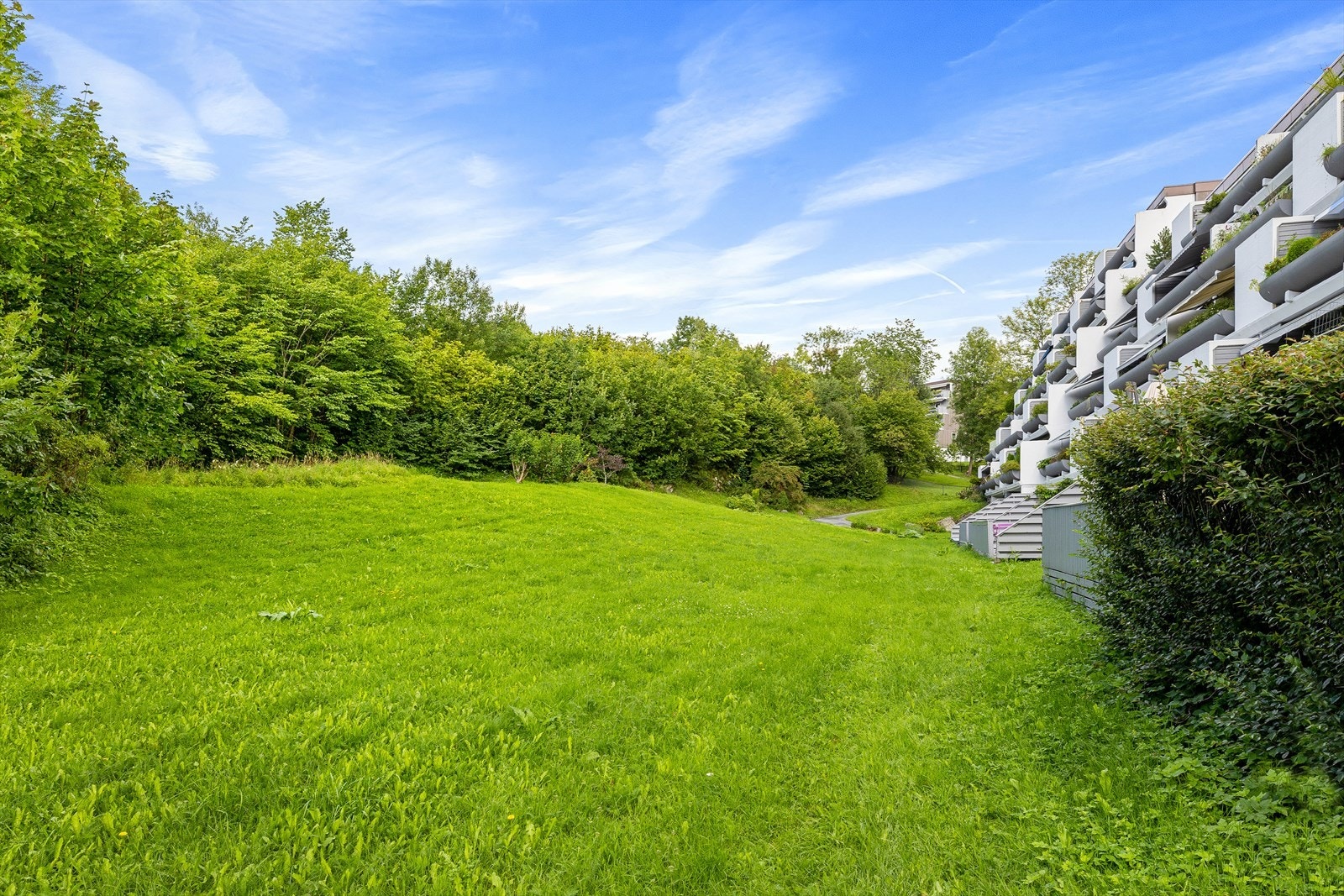 Grøntområder rundt boligen skaper en naturskjønn ramme og en følelse av ro. Galleribilde