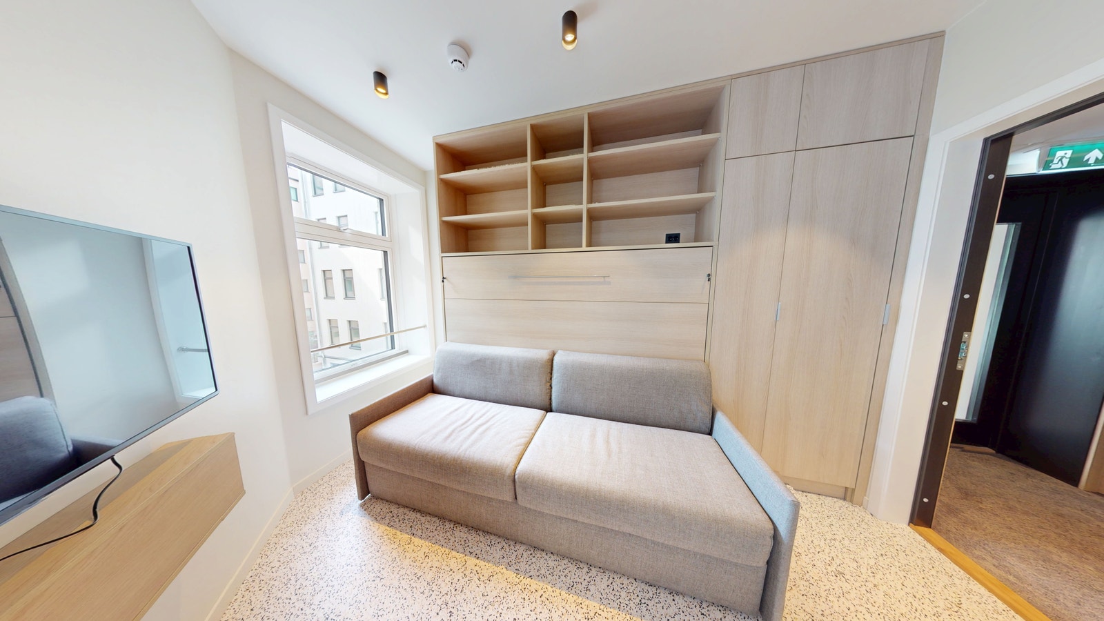 Seng er innebygget i hyllen og kommer ned over sofa Galleribilde