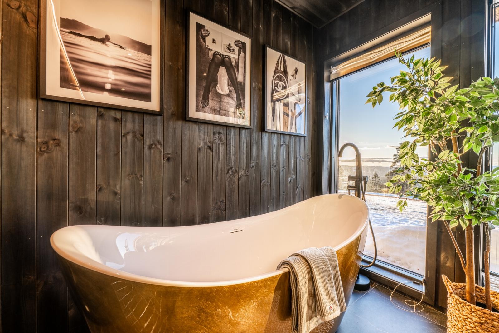 Badet med det gullfargede badekaret inviterer til velvære og komfort. Fra badekaret har man en nydelig utsikt til fjellheimen. Galleribilde