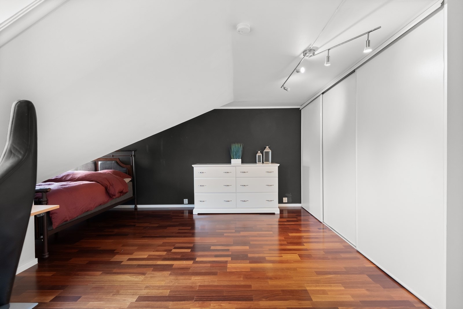 Det ene soverommet har en stor skyvedørsgarderobe montert. Galleribilde