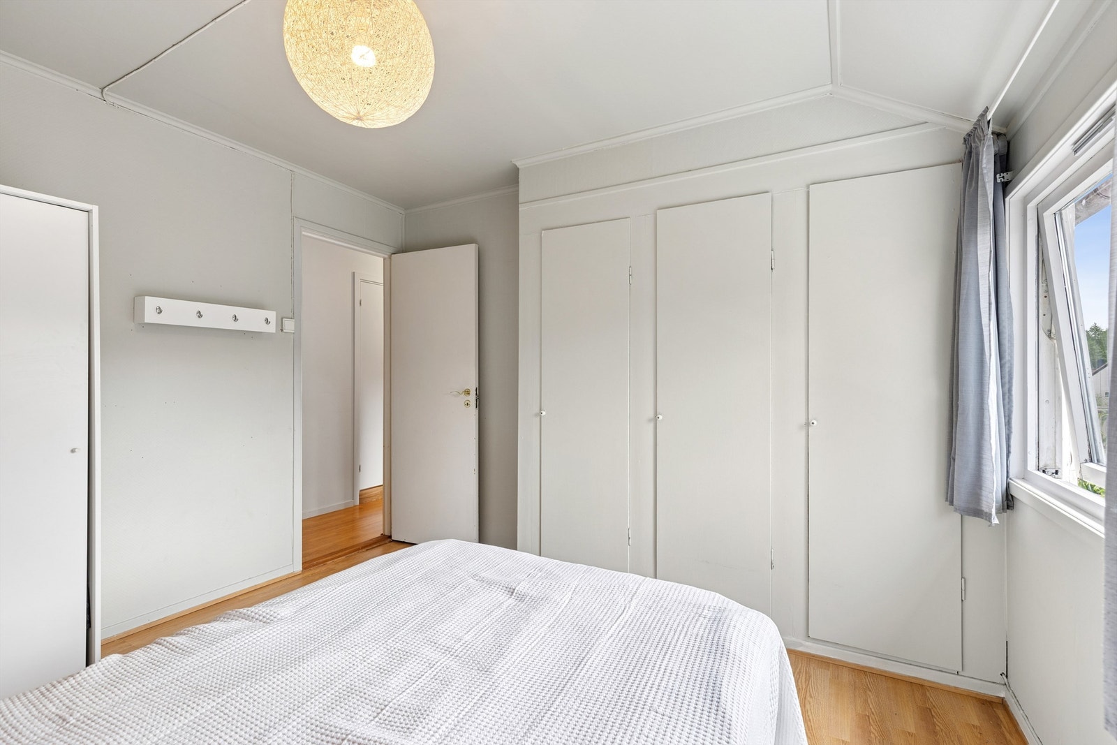 Innebygde skap og en skyvedørsgarderoben gir rikelig plass til oppbevaring av klær Galleribilde